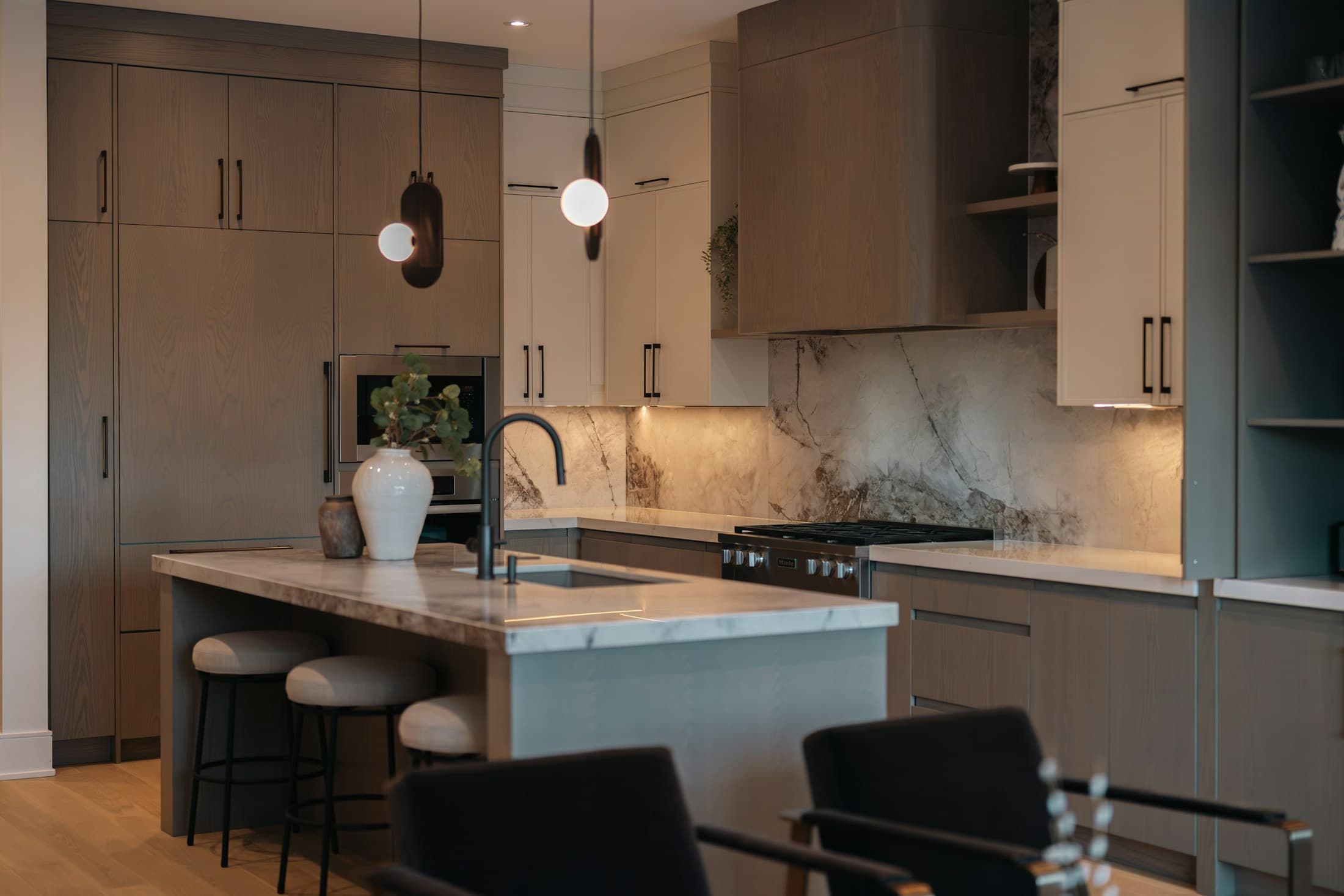 Contemporary kitchen with marble surfaces, warm wood cabinetry and integrated joinery